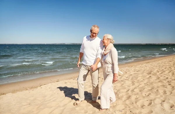 Gelukkige senior paar wandelen langs strand van de zomer — Stockfoto