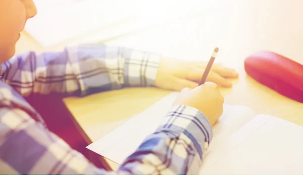 Close up of schoolboy writing test at school — Stockfoto