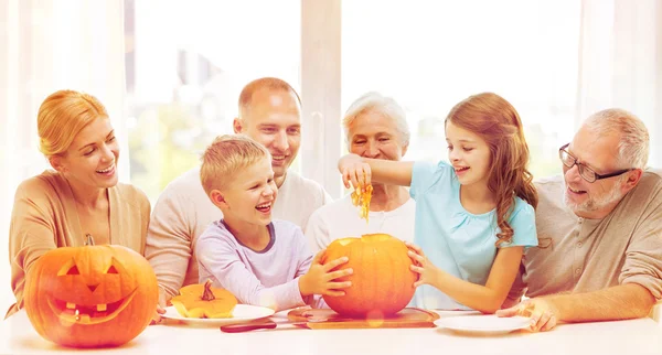 Happy family sitting with pumpkins at home — Stock Photo, Image
