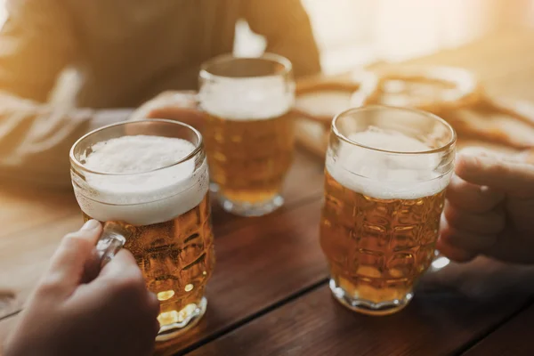 Close up of hands with beer mugs at bar or pub — Stock Photo, Image