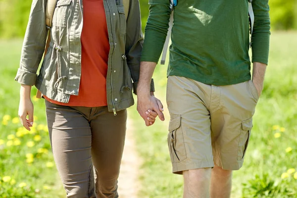 Close up of couple with backpacks holding hands — Stock Photo, Image