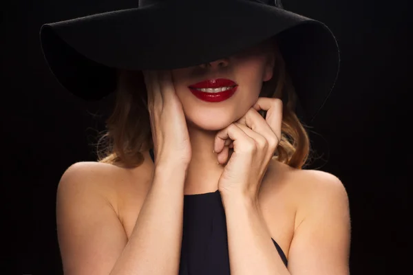 Bela mulher em chapéu preto sobre fundo escuro — Fotografia de Stock