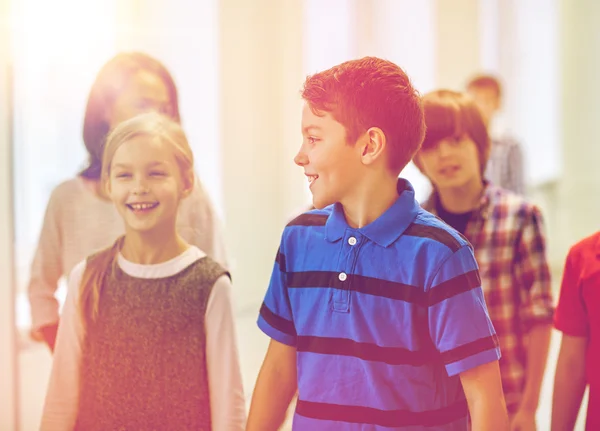 Group of smiling school kids walking in corridor — Stock Photo, Image