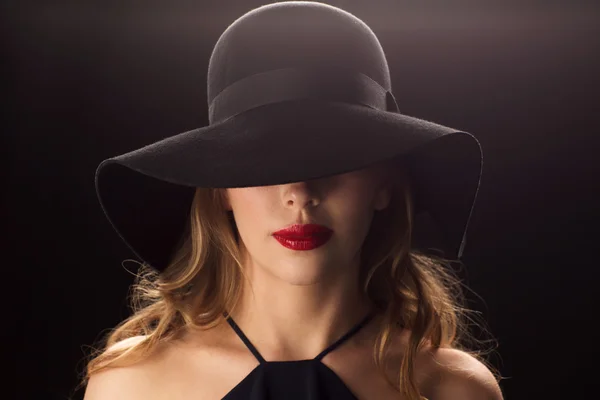 Bela mulher em chapéu preto sobre fundo escuro — Fotografia de Stock