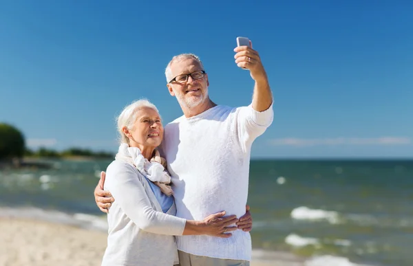 Lyckliga äldre par kramas på sommaren beach — Stockfoto