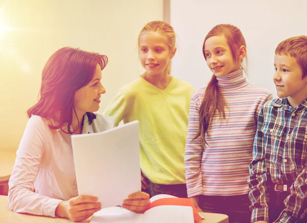 Group of school kids with teacher in classroom Stock Image