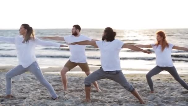 Groep mensen die yoga oefeningen op strand — Stockvideo