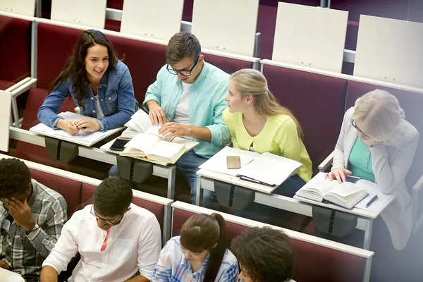 Grupo de estudiantes con cuadernos en la sala de conferencias — Foto de Stock