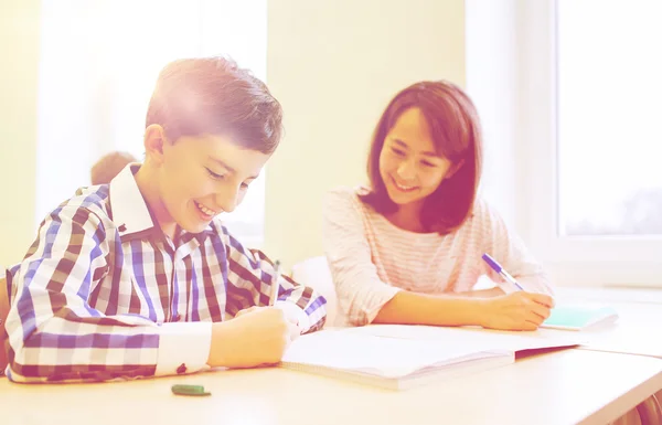 Grupp av skolbarnen skriva prov i klassrummet — Stockfoto