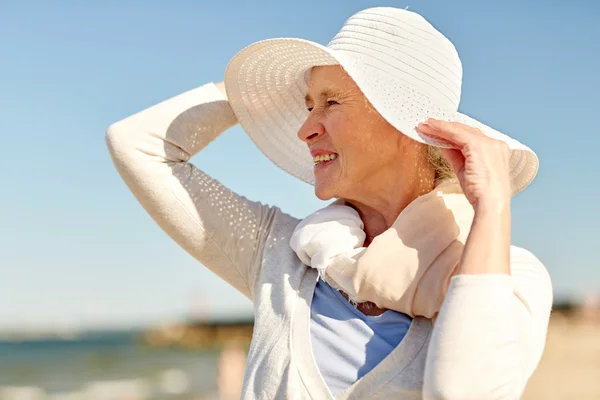 Mulher sênior feliz em chapéu de sol na praia de verão — Fotografia de Stock