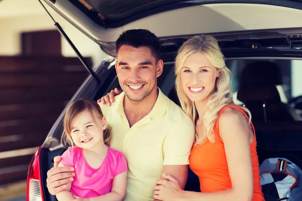 Familia feliz con coche hatchback en el aparcamiento en casa — Foto de Stock