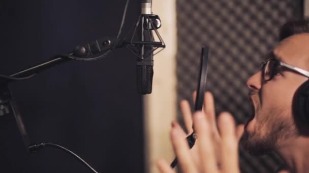 Man with headphones singing at recording studio — Stock Video