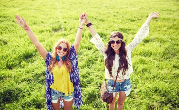 Smilende unge hippiekvinner som danser på grønn mark – stockfoto