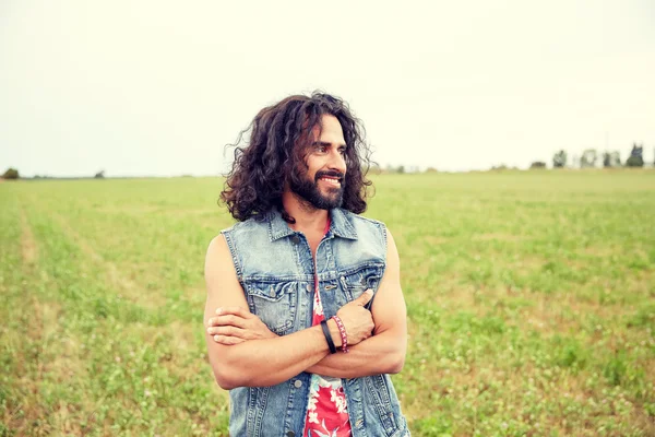 Sorridente jovem hippie homem no campo verde — Fotografia de Stock