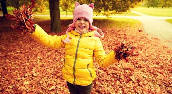 Heureux fille jouer avec automne feuilles dans parc — Photo