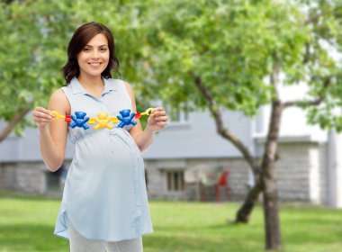 happy pregnant woman holding rattle toy clipart