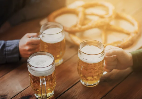 Primer plano de las manos con tazas de cerveza en el bar o pub —  Fotos de Stock