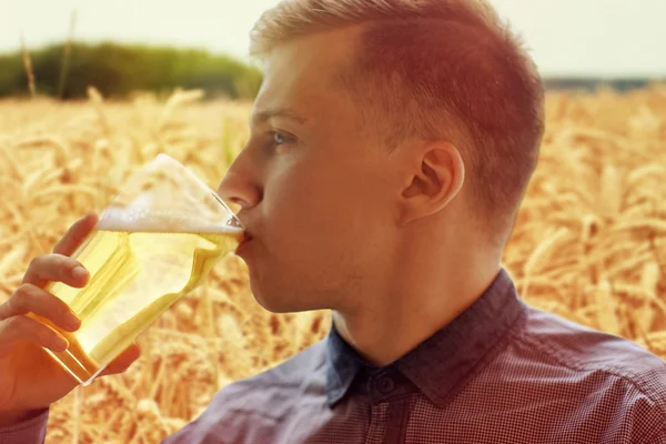 Zbliżenie na młodego człowieka picia piwa ze szkła — Zdjęcie stockowe