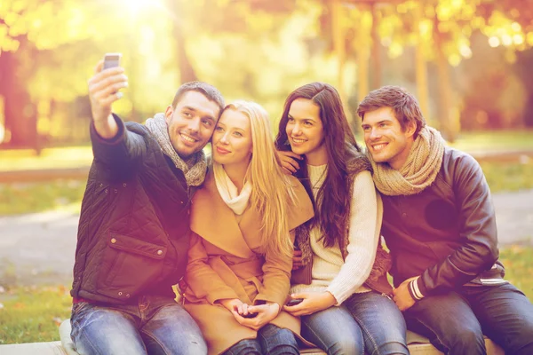 Gruppo di amici con macchina fotografica nel parco autunnale — Foto Stock