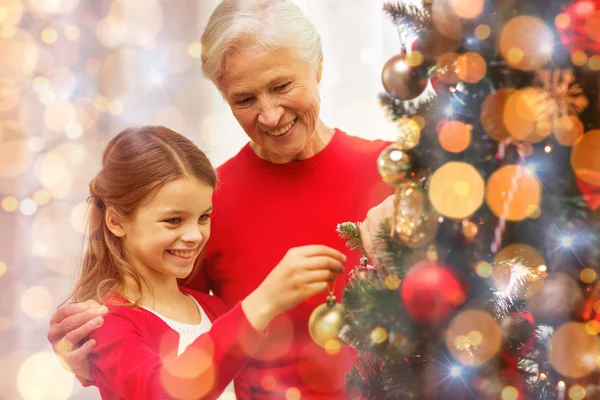 Lächelnde Familie schmückt Weihnachtsbaum zu Hause — Stockfoto