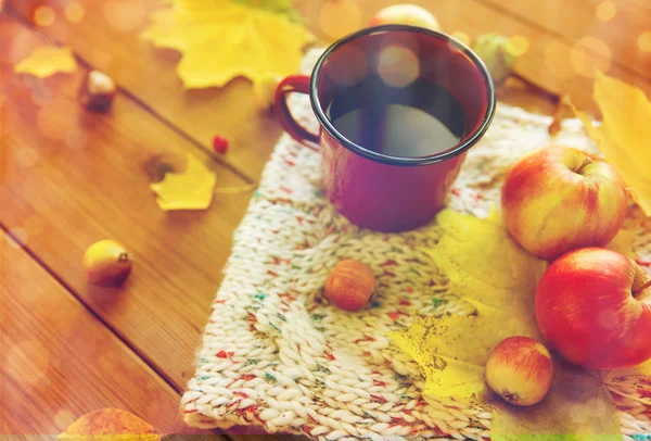 Закрытие чашки чая на столе с осенними листьями — стоковое фото