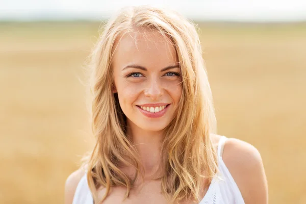 Sorrindo jovem mulher em branco no campo de cereais — Fotografia de Stock