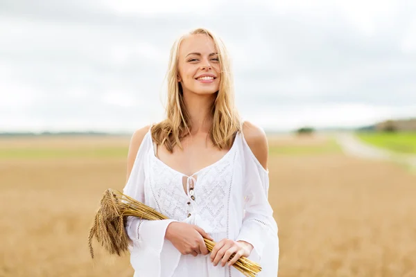 Felice giovane donna con spighette sul campo di cereali — Foto Stock