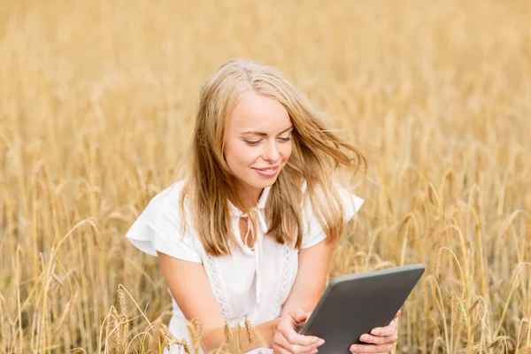 幸せな若い女性とタブレットPCオンシリアルフィールド — ストック写真