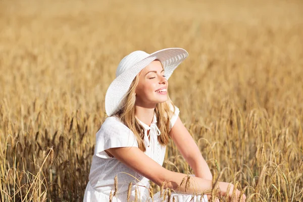 Felice giovane donna in cappello da sole sul campo di cereali — Foto Stock