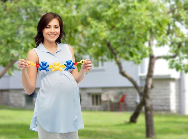 Szczęśliwy Kobieta w ciąży trzymanie grzechotka zabawka — Zdjęcie stockowe