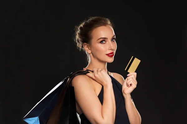 Mulher com cartão de crédito e sacos de compras — Fotografia de Stock