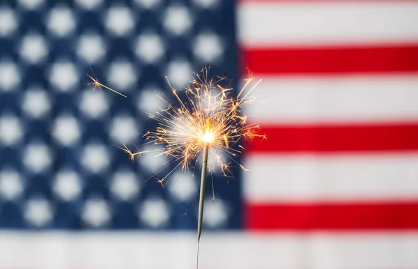 Close up of sparkler burning over american flag — Stock Photo, Image