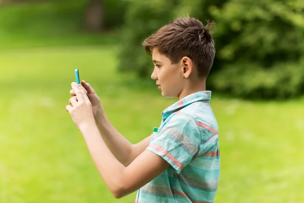 Menino com smartphone jogando jogo no parque de verão — Fotografia de Stock
