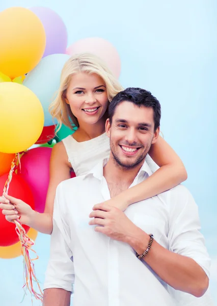 Pareja con globos de colores en la playa — Foto de Stock