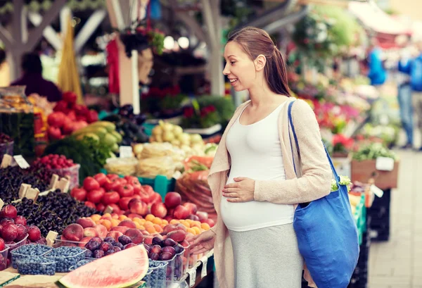 Mujer embarazada eligiendo comida en el mercado callejero —  Fotos de Stock