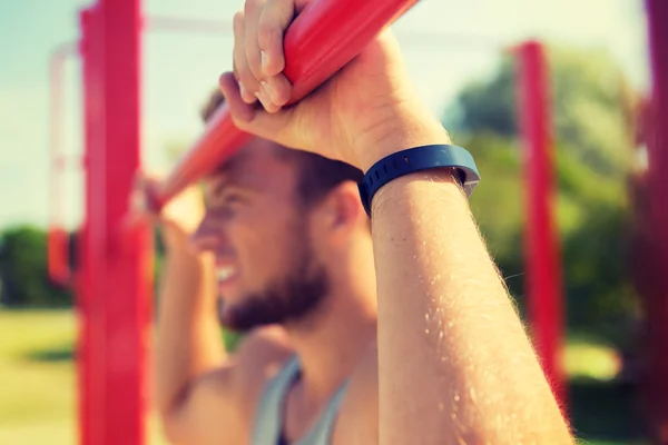 Joven ejercitándose en barra horizontal al aire libre —  Fotos de Stock