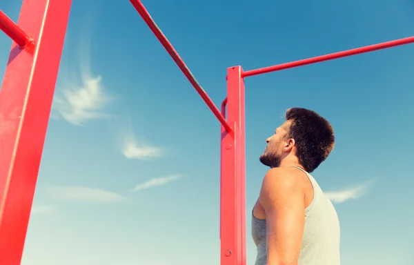 Jongeman die buiten op de horizontale balk traint — Stockfoto