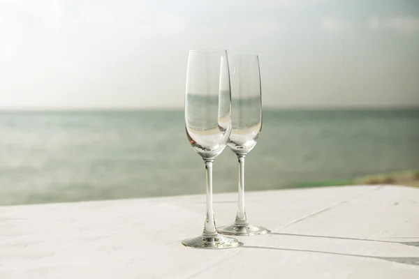 关闭了海滩上的两个香槟杯 — 图库照片