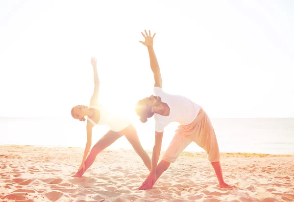 Pareja haciendo ejercicios de yoga al aire libre —  Fotos de Stock
