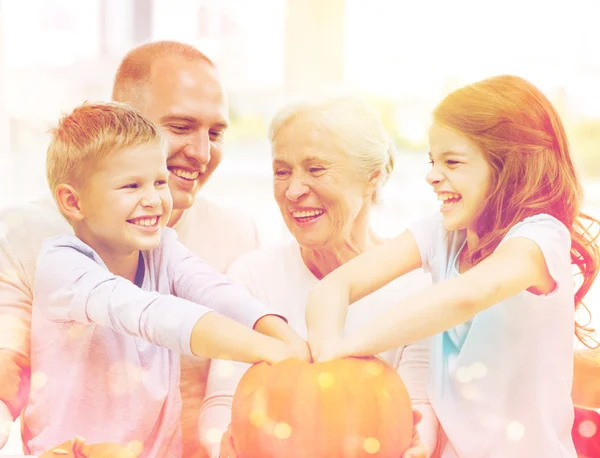 Familia feliz sentado con calabazas en casa —  Fotos de Stock