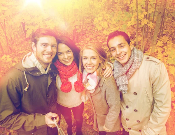 Amici sorridenti scattare selfie nel parco autunnale — Foto Stock
