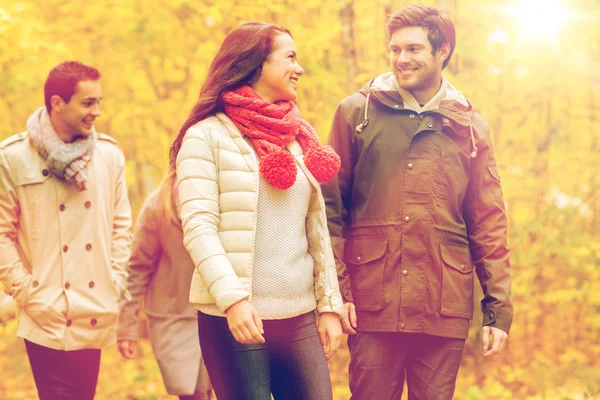 Groep van mannen en vrouwen in de herfst park glimlachen — Stockfoto