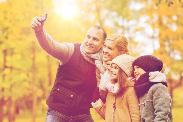 Happy family with camera in autumn park — Stock Photo, Image