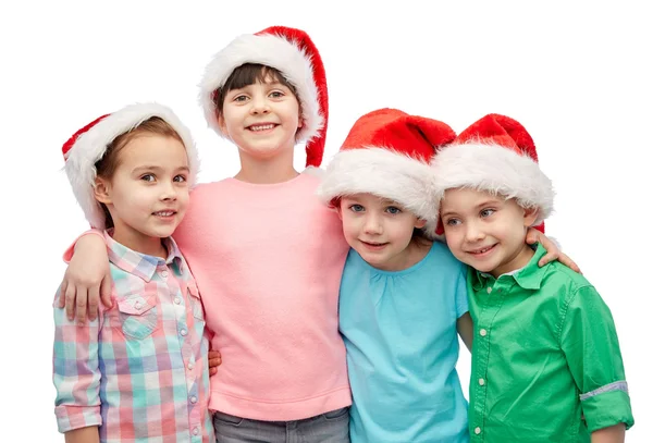 Niños pequeños y felices en sombreros de santa abrazo —  Fotos de Stock