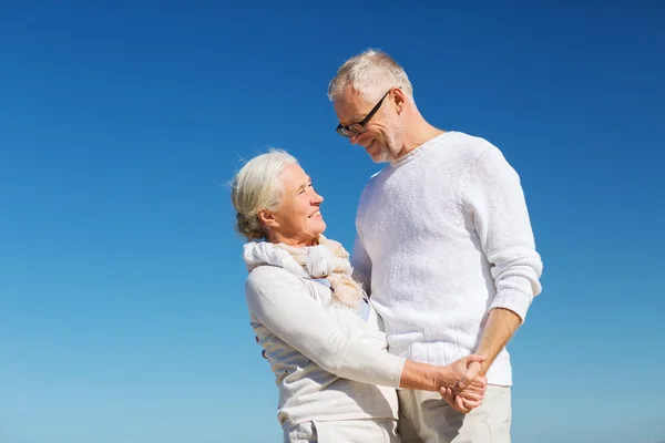 Gelukkige senior paar bedrijf handen op zomer strand — Stockfoto