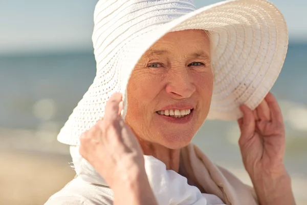 Wanita senior yang bahagia dengan topi matahari di pantai musim panas — Stok Foto