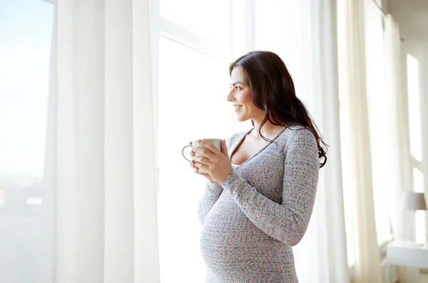 Glad gravid kvinna med kopp dricka te hemma — Stockfoto