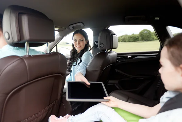 Família feliz com tablet pc dirigindo no carro — Fotografia de Stock