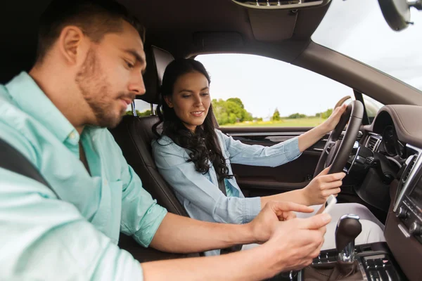 Muž a žena s chytrými telefony, jízdu v autě — Stock fotografie