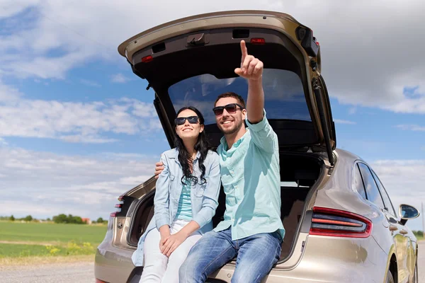 Щаслива пара обіймає відкритий багажник автомобіля — стокове фото